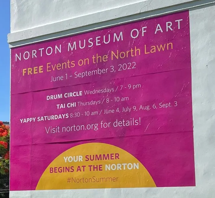 Large pink sign advertising Norton Museum events.