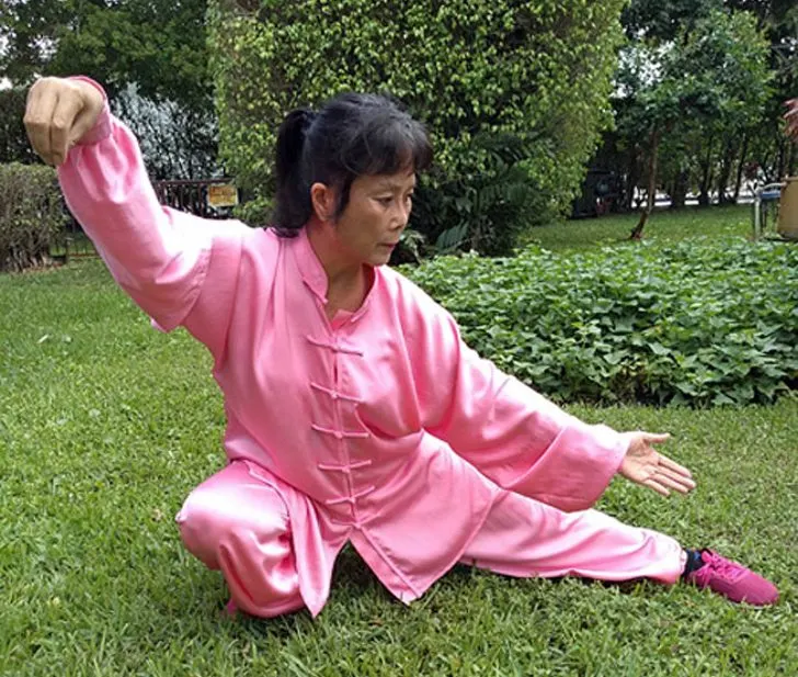 Woman in pink practicing Tai Chi.